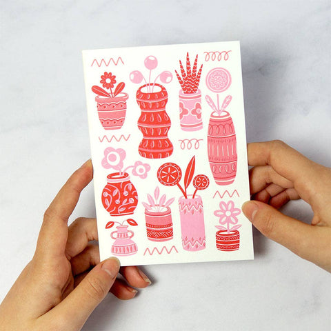 Tarjeta de felicitación con macetas y plantas rojas